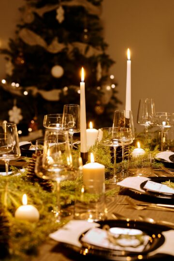 Festive Christmas dinner table adorned with candles and greenery for a cozy atmosphere.