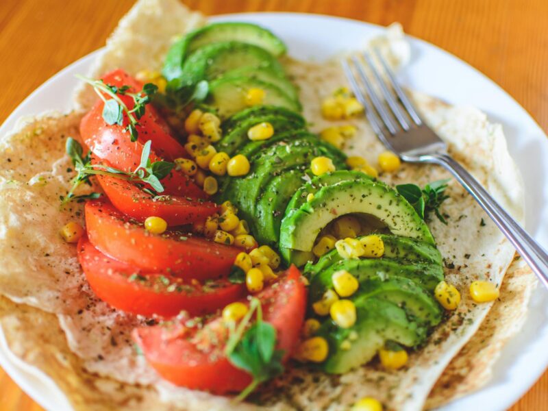 sliced tomato and avocado on white plate